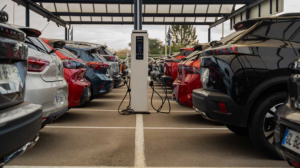 Parc automobiles de Peugeot avec une borne de recharge